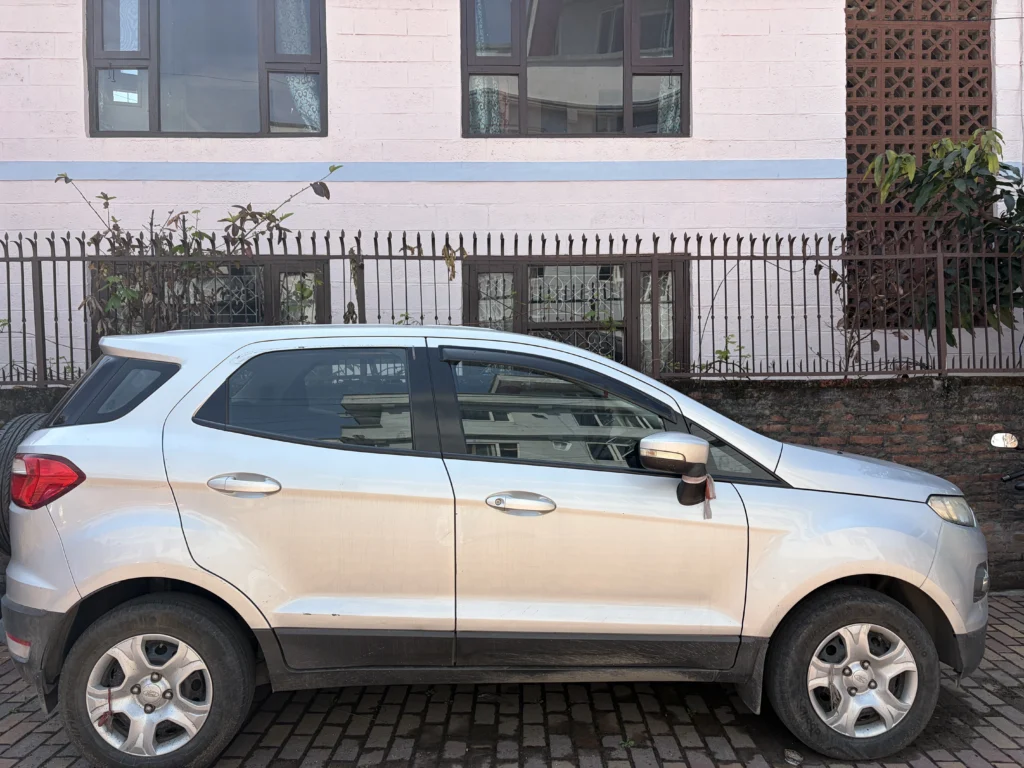Silver car parked beside building