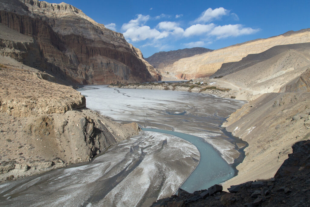 Layered cliffs and winding river in barren Himalayan valley