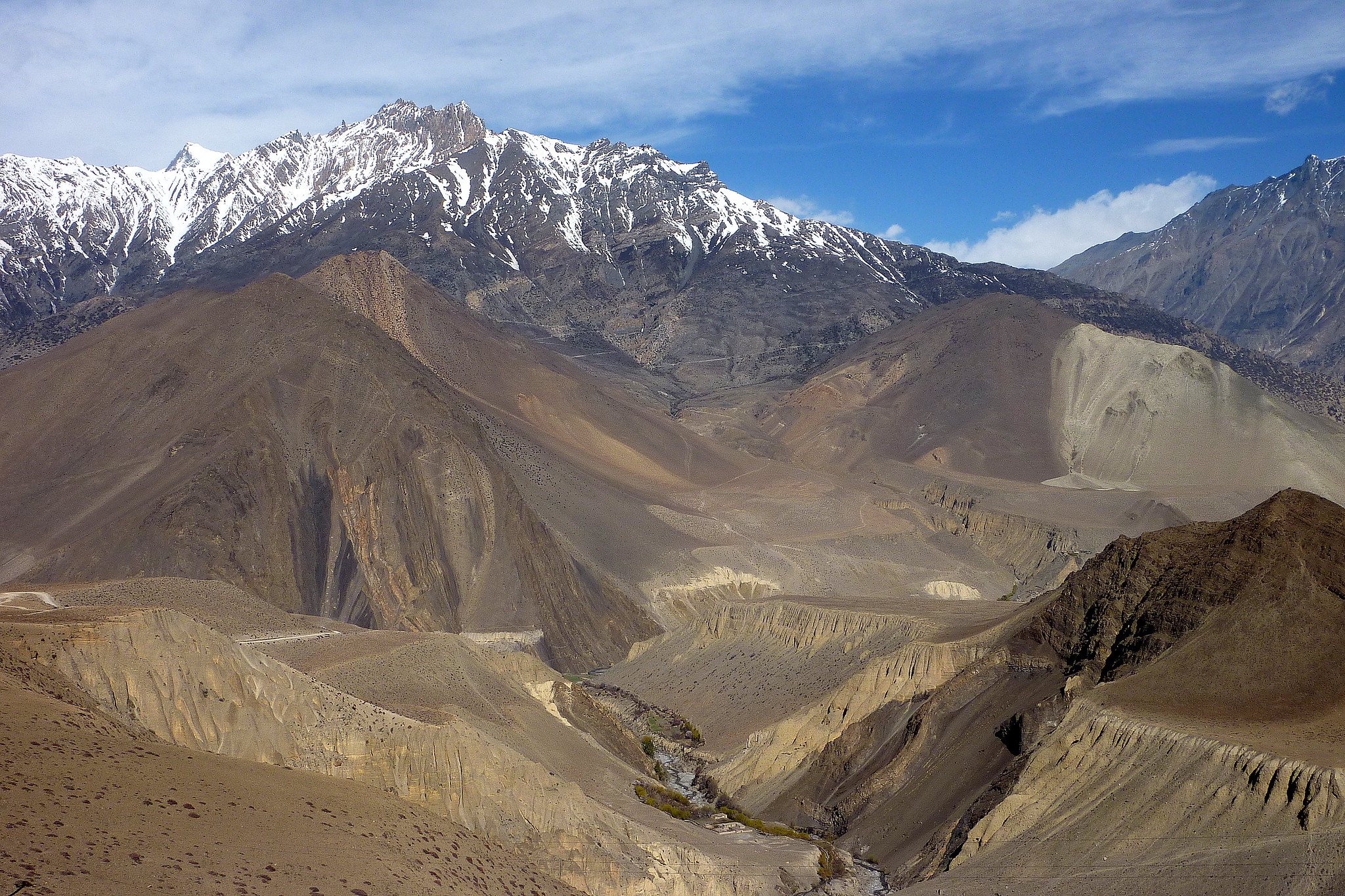 Snow-capped peaks above rocky Himalayan valley with river