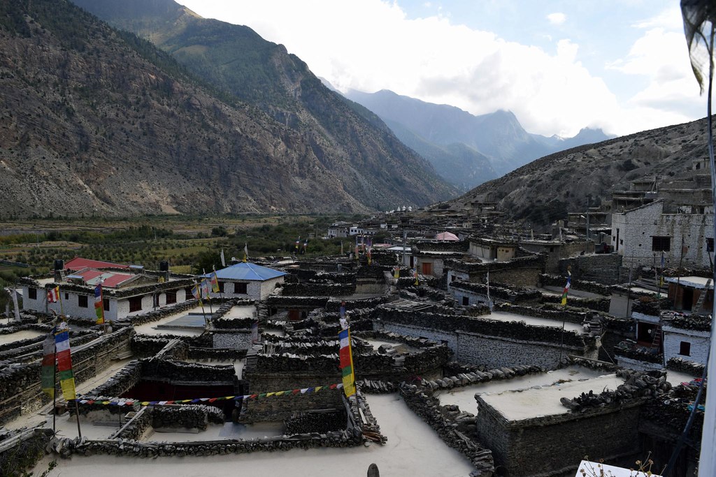 Mountain village with stone houses and prayer flags